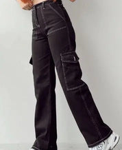 Pantaloni cargo neri da donna con cuciture bianche, tasche laterali, vestibilità ampia, abbinati a scarpe sportive bianche.