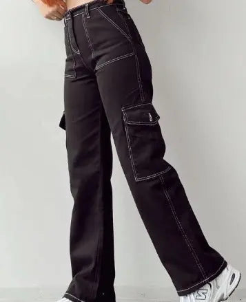 Pantaloni cargo neri da donna con cuciture bianche, tasche laterali, vestibilità ampia, abbinati a scarpe sportive bianche.