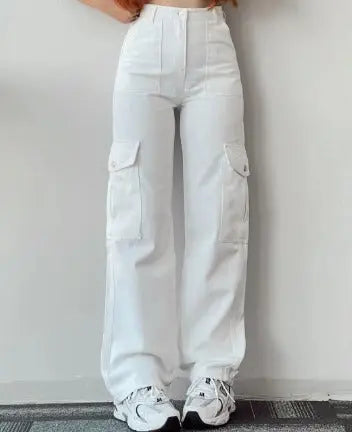 Pantaloni cargo bianchi da donna, a vita alta, con tasche laterali, abbinati a scarpe da ginnastica bianche. Moda casual femminile.
