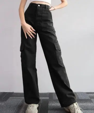 Pantaloni cargo neri da donna a vita alta, tasche laterali, stile casual, moda streetwear, abbinati a scarpe sportive bianche.