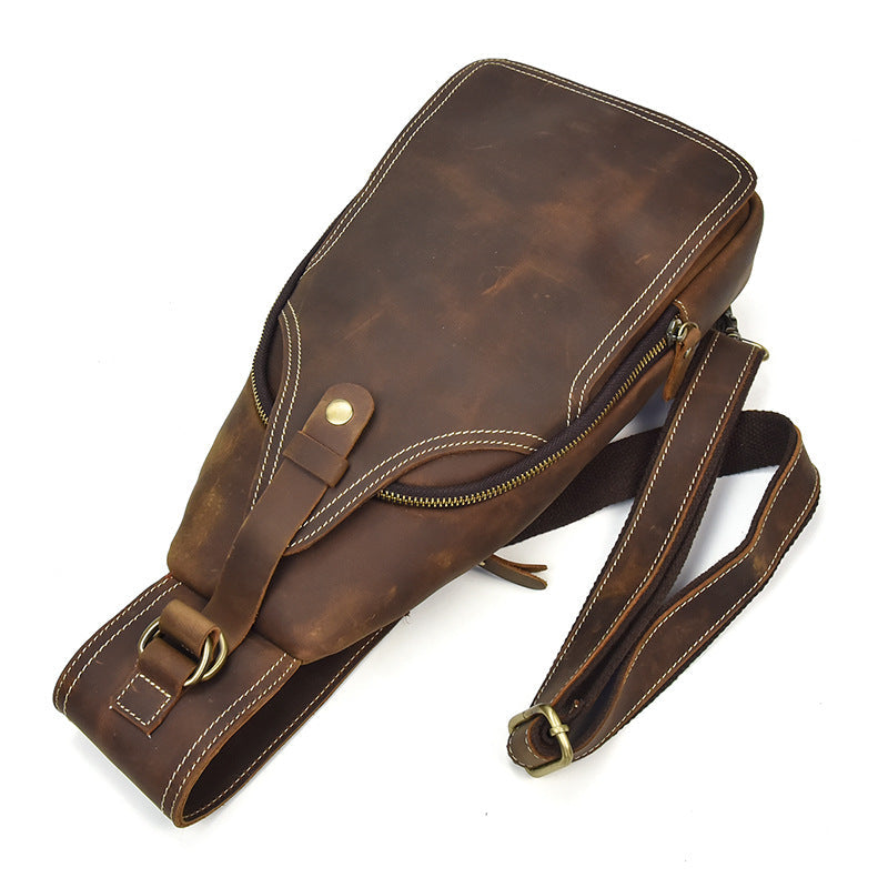 Zaino monospalla in pelle marrone vintage, con cerniera e fibbia regolabile. Design elegante e pratico per uomo e donna.