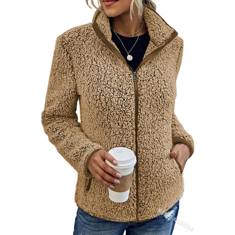 Giacca in pile teddy beige da donna, con zip frontale, indossata con jeans. Perfetta per l'inverno, moda casual, calda e confortevole.
