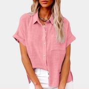 Camicia donna rosa in lino, maniche corte, colletto classico, abbinata a pantaloni bianchi. Stile casual estivo, moda femminile elegante.