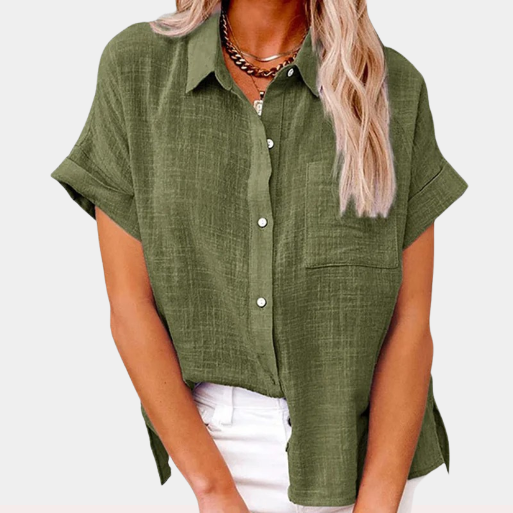 Camicia verde oliva da donna in lino, maniche corte, colletto classico, tasca frontale, abbinata a pantaloni bianchi. Moda estiva casual.