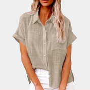Blusa donna beige in lino, maniche corte, colletto classico, abbottonatura frontale, tasca sul petto, stile casual estivo.