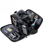 Borsa da toilette in pelle nera aperta, con scomparti organizzati contenenti spazzolino, rasoio, pettine e prodotti per la cura personale.