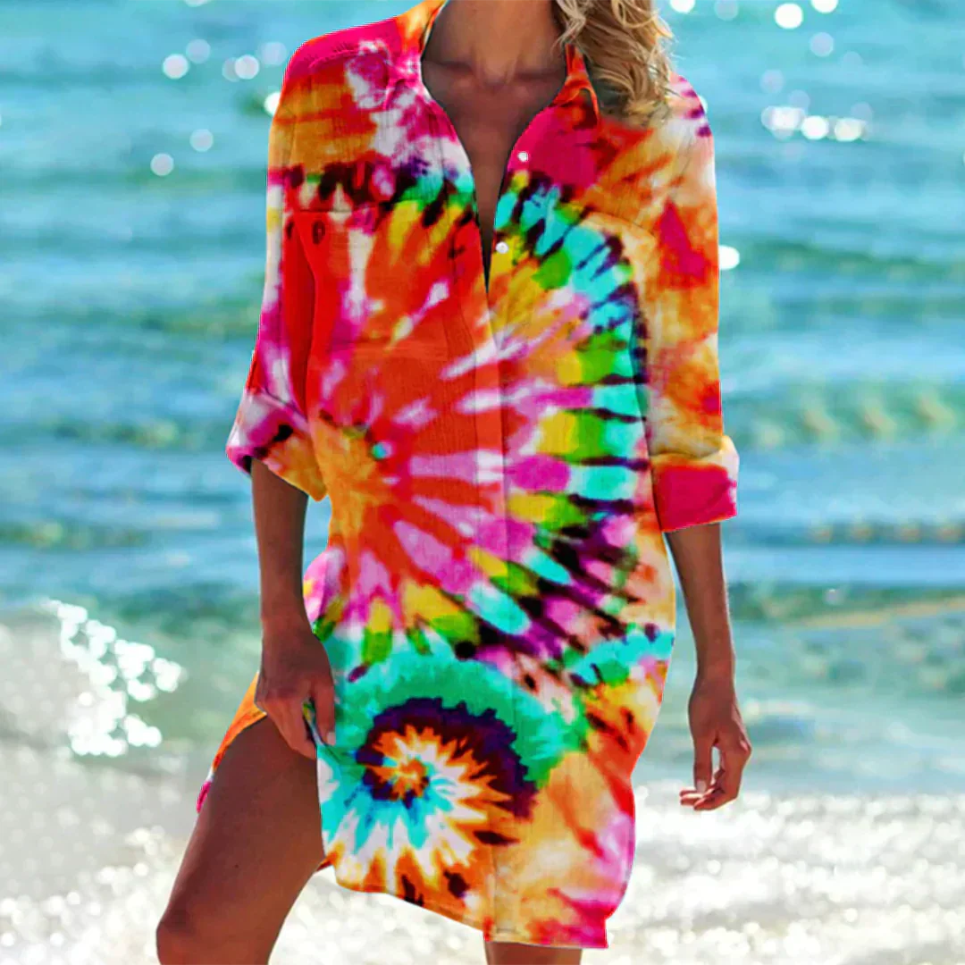 Abito da spiaggia donna, fantasia tie-dye multicolore, maniche lunghe, sfondo mare. Moda estiva, copricostume vivace, look casual.