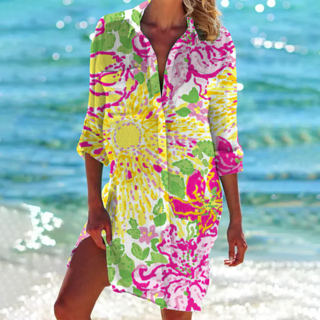 Abito estivo donna, fantasia floreale colorata, maniche lunghe, sfondo mare. Perfetto per spiaggia, moda estiva, look casual elegante.
