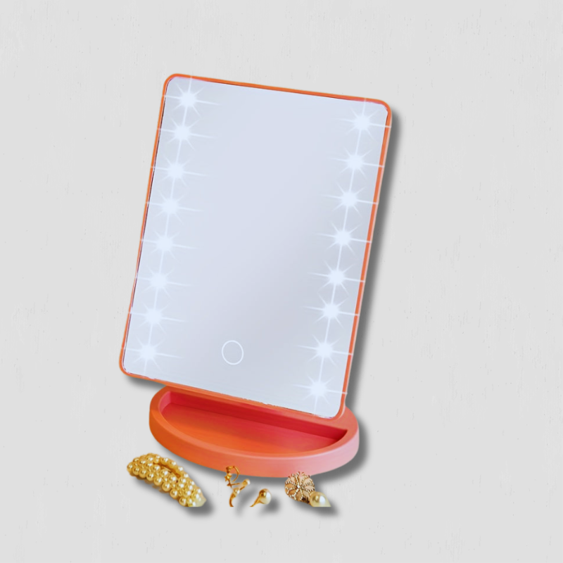 Specchio cosmetico LED rettangolare con cornice arancione, base rotonda e accessori gioiello dorati. Ideale per trucco e illuminazione uniforme.