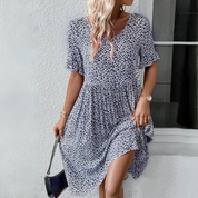 Abito estivo donna a fiori blu e bianchi, maniche corte, scollo a V, tessuto leggero. Perfetto per moda casual e look estivi eleganti.