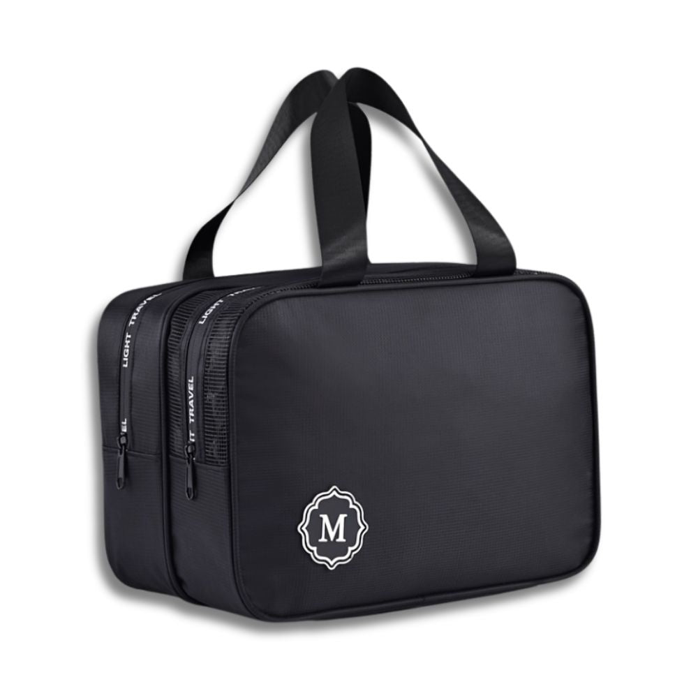 Borsa da viaggio nera con doppio scomparto, manici robusti e logo "M". Ideale per organizzare accessori e articoli da toeletta.