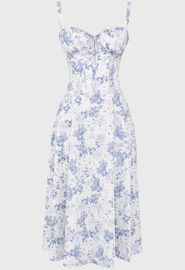 Abito estivo floreale bianco e blu, senza maniche, con spalline sottili e scollo a cuore. Design elegante e femminile, perfetto per occasioni estive.