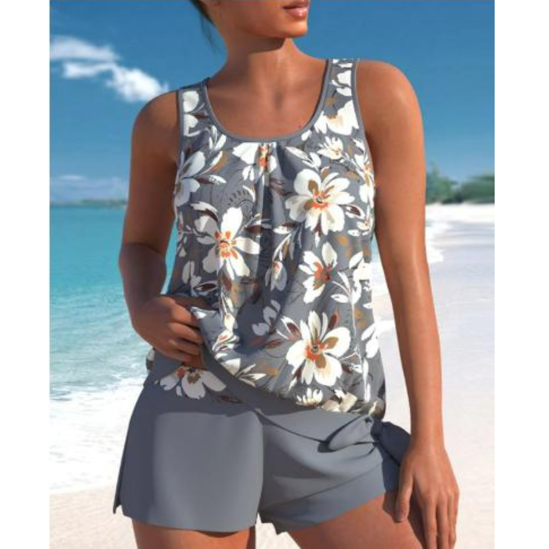 Top estivo donna floreale, senza maniche, su spiaggia tropicale. Moda mare, abbigliamento casual, look estivo elegante.