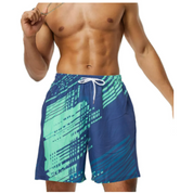 Pantaloncini da bagno uomo blu con stampa geometrica verde, elastico in vita e coulisse. Ideali per nuoto e spiaggia. Moda mare estiva.