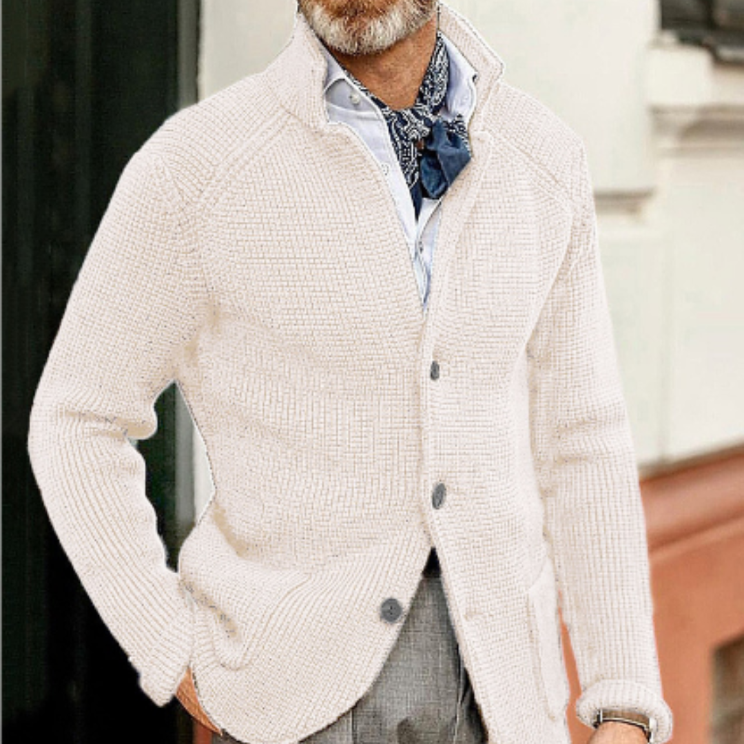 Giacca cardigan uomo beige in maglia, abbinata a camicia bianca e foulard blu. Moda maschile elegante, stile autunnale casual chic.