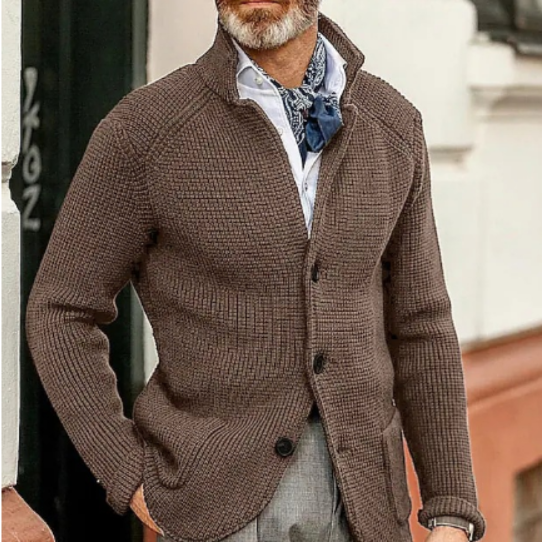 Giacca cardigan marrone da uomo in maglia, abbinata a camicia bianca e cravatta blu, stile casual elegante, perfetta per l'autunno.