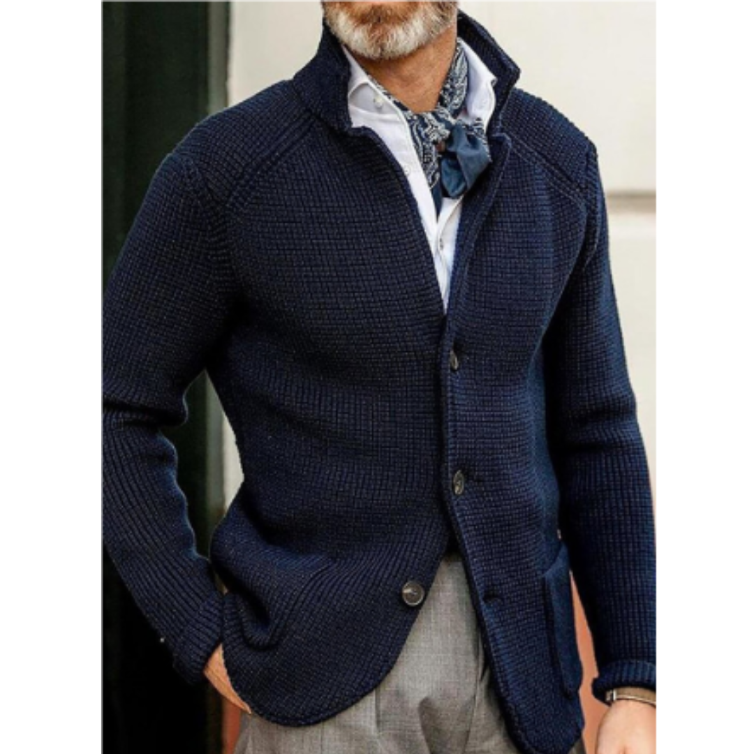 Giacca uomo blu scuro in maglia, abbinata a camicia bianca e foulard, stile elegante e casual, ideale per moda autunnale e invernale.
