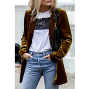 Giacca di velluto marrone donna, abbinata a jeans e maglietta bianca con stampa "1988". Look casual chic, moda autunnale, stile urbano.