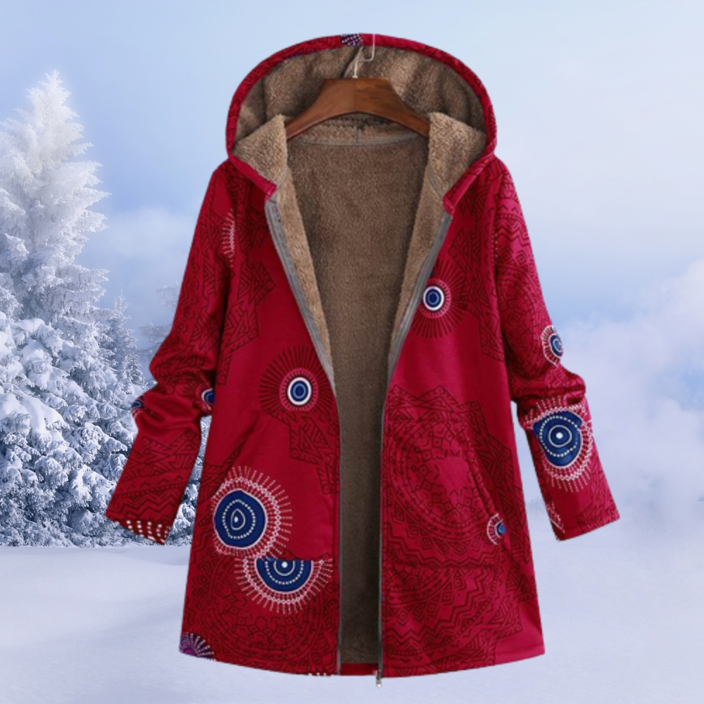 Cappotto invernale rosso con cappuccio, motivo etnico, foderato in pelliccia sintetica, appeso su gruccia, sfondo innevato. Moda donna, abbigliamento caldo.
