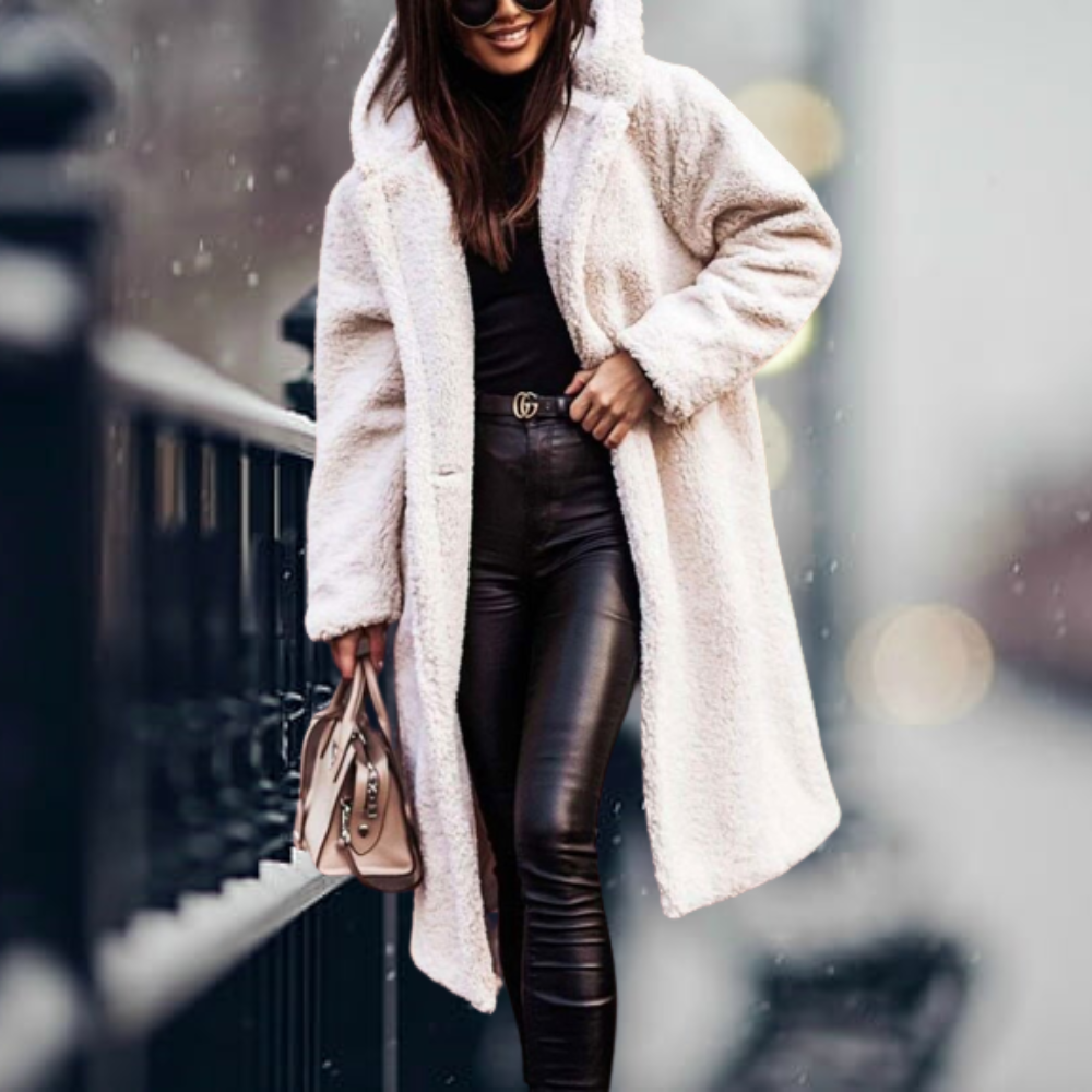 Donna con cappotto in pelliccia sintetica bianca, pantaloni in pelle nera, borsa beige, occhiali da sole, passeggia in città. Moda invernale elegante.
