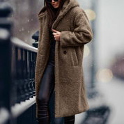Cappotto teddy bear marrone lungo, donna in strada innevata, moda invernale, cappotto caldo e morbido, stile casual chic, abbigliamento femminile.