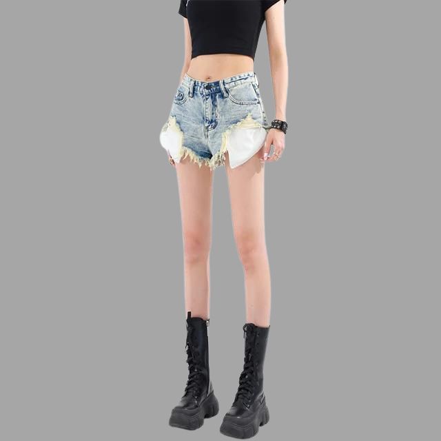 Shorts di jeans strappati da donna, vita alta, con tasche bianche a vista. Abbinati a top nero e stivali neri alti. Moda casual estiva.