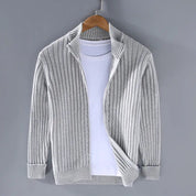 Cardigan grigio a coste su gruccia, abbinato a t-shirt bianca. Moda uomo, abbigliamento casual, maglione leggero, stile autunnale.