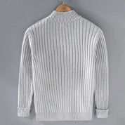 Maglione grigio a coste, maniche lunghe, collo alto, su gruccia. Design elegante e caldo, ideale per moda autunno-inverno uomo.