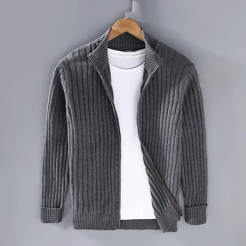 Cardigan grigio a coste per uomo, aperto, con maglietta bianca sotto, appeso su gruccia. Moda casual, abbigliamento autunnale, stile elegante.