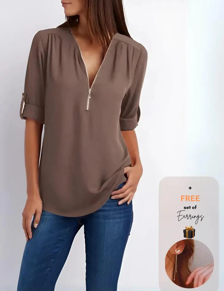 Blusa marrone con zip frontale, maniche arrotolate, abbinata a jeans blu. Offerta: set di orecchini in omaggio. Moda casual donna.