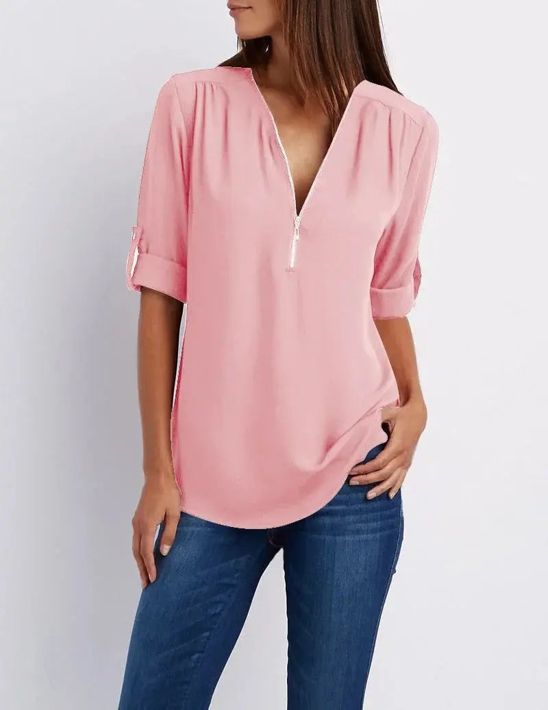 Donna con camicia rosa a maniche lunghe e zip, abbinata a jeans blu. Moda casual femminile, abbigliamento primaverile, stile elegante.