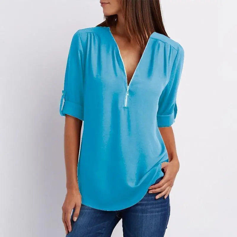 Blusa donna azzurra con scollo a V e maniche a tre quarti, abbinata a jeans. Moda casual elegante, ideale per primavera estate.