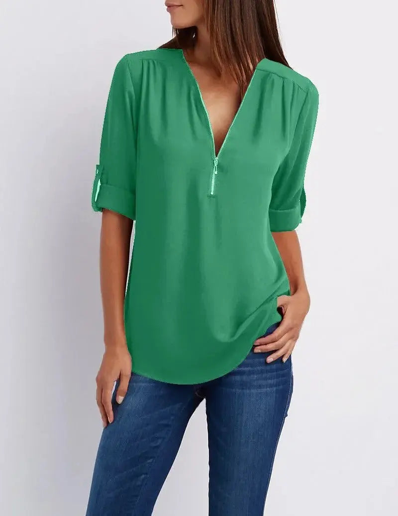 Blusa verde donna con scollo a V e maniche a 3/4, abbinata a jeans blu. Moda casual elegante, perfetta per look quotidiani.