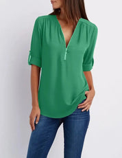 Blusa verde donna con scollo a V e maniche a 3/4, abbinata a jeans blu. Moda casual elegante, perfetta per look quotidiani.