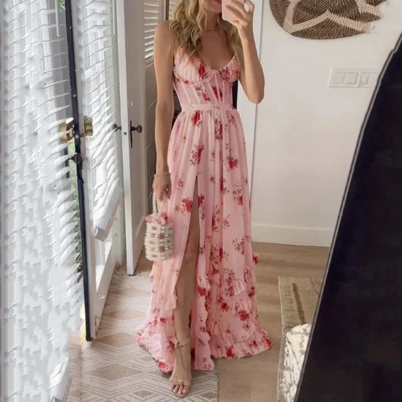 Abito lungo estivo floreale rosa con spacco, indossato da donna in interni. Vestito elegante, moda femminile, tendenze abbigliamento 2023.