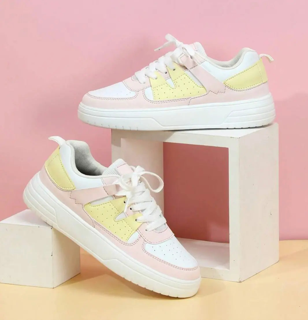 Scarpe da ginnastica bianche e rosa pastello su sfondo rosa, design moderno, suola spessa, perfette per moda casual e sportiva.