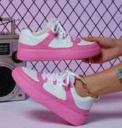 Scarpe da ginnastica bianche e rosa su sfondo a griglia, design moderno, suola spessa, moda casual, accessorio alla caviglia, tendenze 2023.