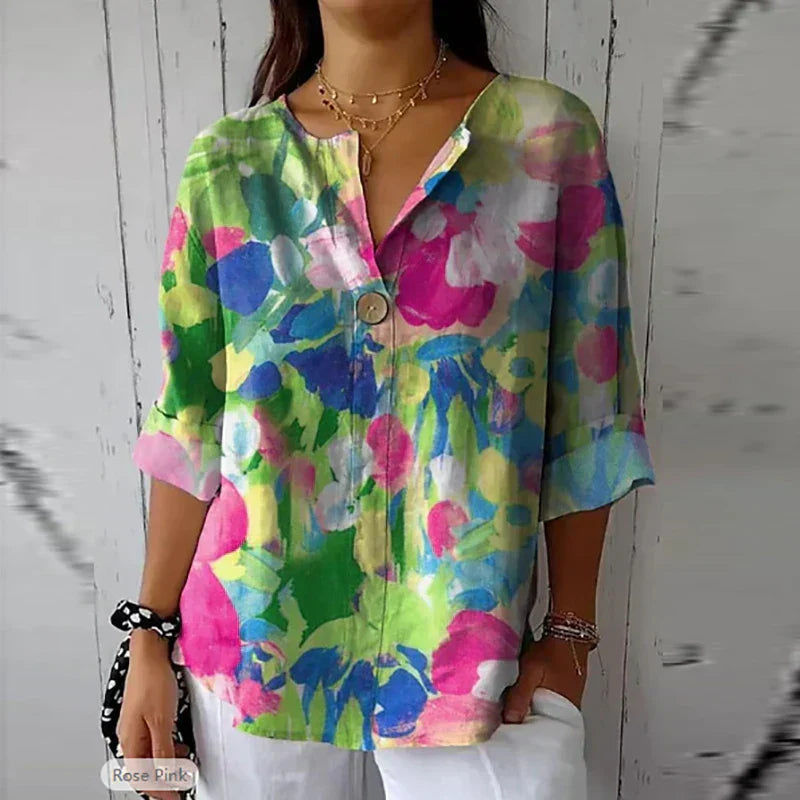 Camicia donna floreale colorata, maniche a tre quarti, scollo a V, bottoni, stile casual estivo, tessuto leggero, moda femminile trendy.