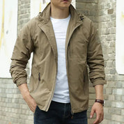 Giacca uomo beige casual, zip frontale, tasche laterali, indossata con t-shirt bianca e jeans. Moda maschile autunnale, stile urbano.
