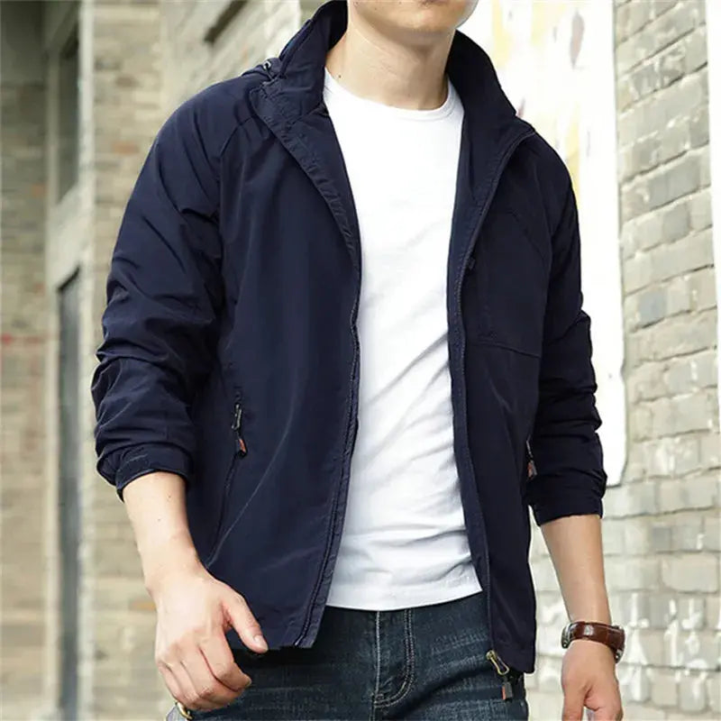 Giacca uomo blu scuro casual, zip frontale, maniche lunghe, abbinata a t-shirt bianca e jeans. Moda maschile autunnale, stile urbano.