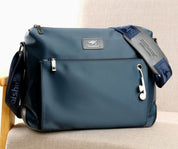 Borsa a tracolla blu in tessuto impermeabile, con cerniere argentate e tracolla regolabile. Design moderno, ideale per uomo e donna.