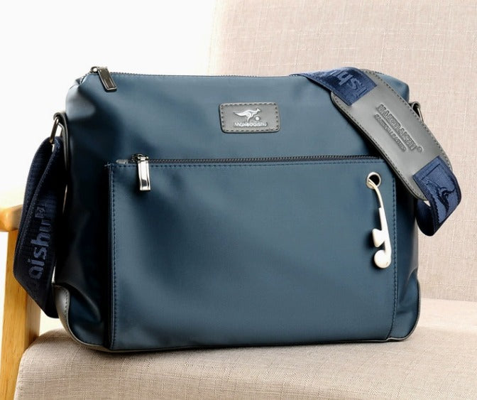 Borsa a tracolla blu in tessuto impermeabile, con cerniere argentate e tracolla regolabile. Design moderno, ideale per uomo e donna.