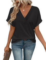 Maglietta nera a maniche corte con scollo a V, indossata con jeans blu. Stile casual, moda donna, abbigliamento estivo elegante.