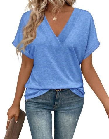 Donna con maglietta blu a V, jeans aderenti, borsa marrone. Moda casual estiva, abbigliamento femminile trendy, look quotidiano elegante.