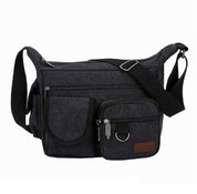 Borsa a tracolla in tela nera con tasche multiple e cerniere, design unisex, ideale per viaggi e uso quotidiano. Accessorio moda pratico e resistente.