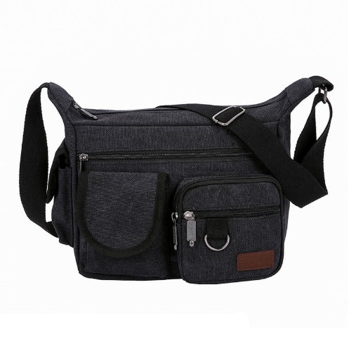 Borsa a tracolla in tela nera con tasche multiple e cerniere, design unisex, ideale per viaggi e uso quotidiano. Accessorio moda pratico e resistente.