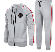 Tuta sportiva grigia da uomo con cappuccio, dettagli a righe rosse e nere, chiusura a zip, pantaloni abbinati. Abbigliamento casual e confortevole.
