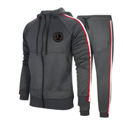 Tuta sportiva grigia da uomo con cappuccio, strisce rosse e bianche, logo sul petto. Completo casual per allenamento e tempo libero.