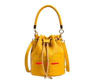 Borsa secchiello gialla in pelle con manico e chiusura a coulisse, design moderno, accessorio moda donna elegante e versatile.