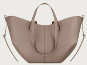 Borsa a mano in pelle beige, design elegante e moderno, con manici corti e dettagli laterali. Accessorio di moda per donna.
